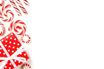 Christmas side border of red and white gifts and peppermint candies over a white background