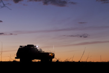 SUV silhouette on sunset sky background