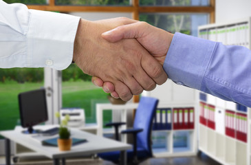 Hände beim Vertragsabschluss im Büro