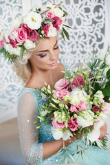 Naklejka premium Gorgeous bride in wedding blue dress flowers wreath and bouqute