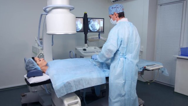 Radiologist performs operation on angiography machine, interventional radiology