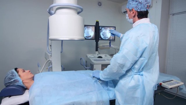 Interventional radiologist performs endovascular surgery operation with angiography machine