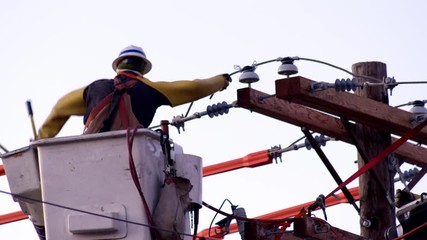 Utility workers in cherry picker working on power line - Powered by Adobe