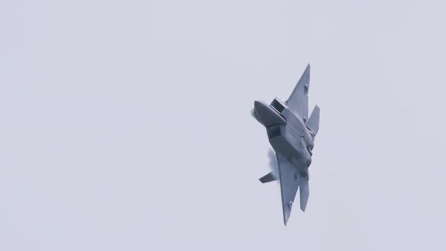 Tracking shot of military fighter airplane flying in sky