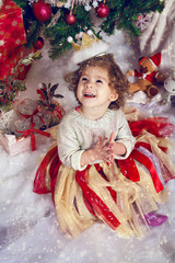 Cute girl looking up at the falling snowflakes