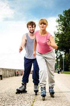 Active young people friends rollerskating outdoor.