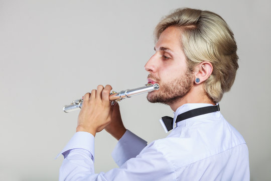 Male flutist playing his flute