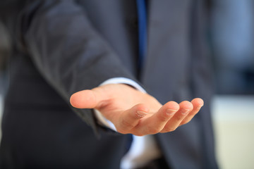 Bribe concept. Man in suit offering a palm