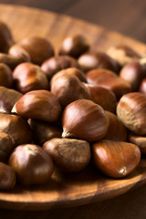 Chestnuts on wooden plate, photographed with natural light (Selective Focus, Focus one third into the chestnuts)