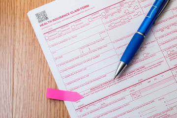 Health insurance claim form with pen on a desk.