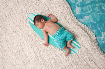 Fototapeta na wymiar Newborn Baby Boy on Surfboard