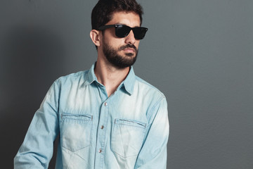 Young hipster bearded man with sunglasses - gray background