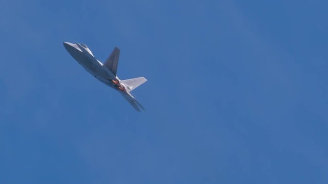 Slow motion of F22 fighter jet flying in blue sky