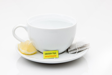 Cup and saucer with tea bag and lemon wedge