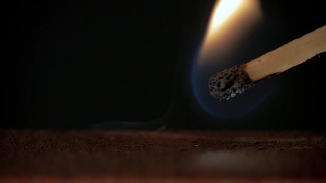 Firing point safety match. Close-up view to strike matches for matchbox. Detail of ignition matches for matchbox. Macro lighting of a match striking out a matchbox. Closeup safety match flame.