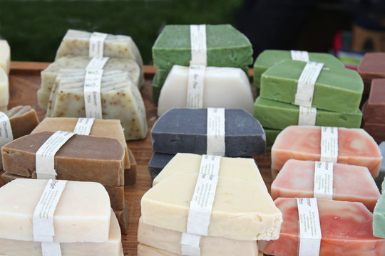 Colorful handmade soaps with ingredients marked on white strips in a market