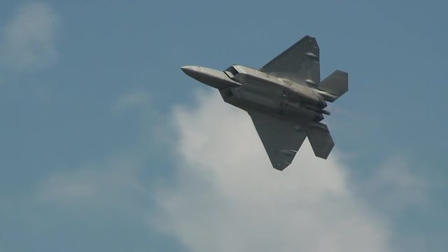Tracking shot of F22 fighter jet flying in sky