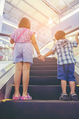 child catch hand together up escalator - 124201511