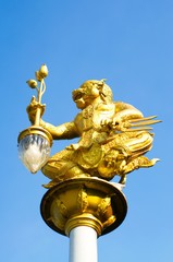 Fototapeta na wymiar Lighting pole. Figure stucco monkey holding lanterns light the way at night.