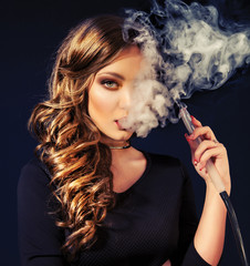 Young, beautiful girl in club dress and perfect make up smoke a