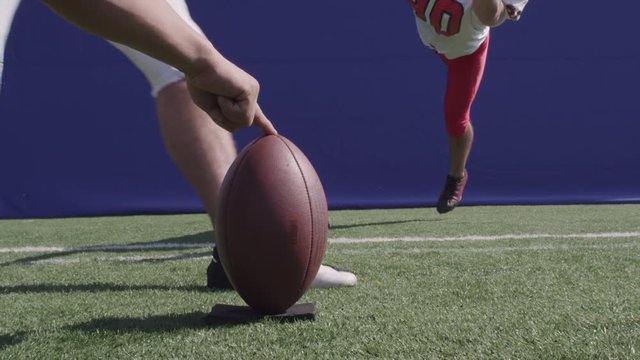 Football player kicks a field goal, CU slow motion bluescreen.