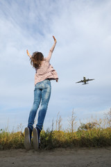 Fototapeta premium Young beautiful girl jumping happy journey. It looks like a plane taking off from the runway.
