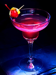 Alcohol cocktail with cherry on black background. Cocktail decoration by lemon slice.