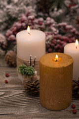 Fototapeta na wymiar Fir branch in snow, lighted candle, cone on wooden background. Christmas theme