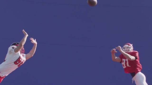 Football bluescreen, a football player catches a pass in mid-air, slow motion.