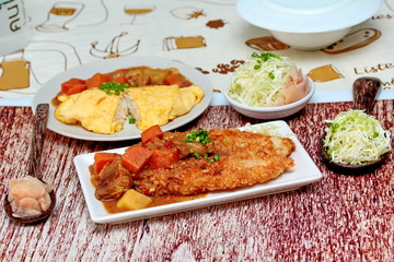Close up deep fried dolly fish in Japanese style topped yellow curry with sliced cabbage and pickled ginger. Selective focus.