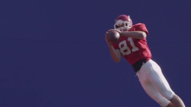 Football bluescreen, a football player catches a football in mid-air with bluescreen.