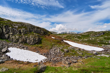 Summer mountain landscape in Telemark, Norway, with snow areas on ground and mountain sides