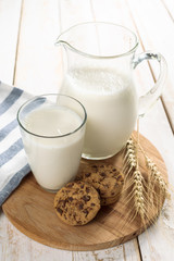 fresh milk in glass jug and glass on wooden background