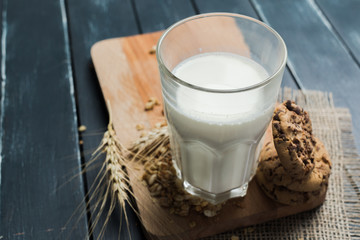 Glass of milk on table on blurred natural background