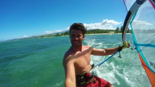 POV windsurfer gliding across blue ocean, extreme sport