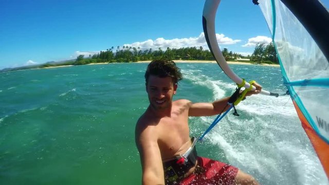 POV windsurfer gliding across blue ocean, extreme sport