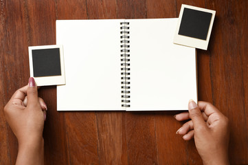 Obraz premium Blank notebook and photo frames on hand for background