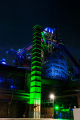 old lift shaft at illuminated industrial plant by night