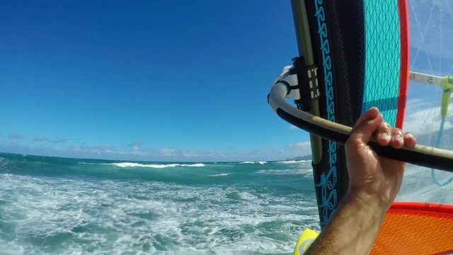 POV windsurfer gliding across blue ocean, extreme sport