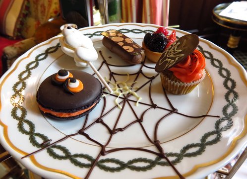 Halloween treats including monster cookie, ghost meringue, cupcake with chocolate bat and orange frosting