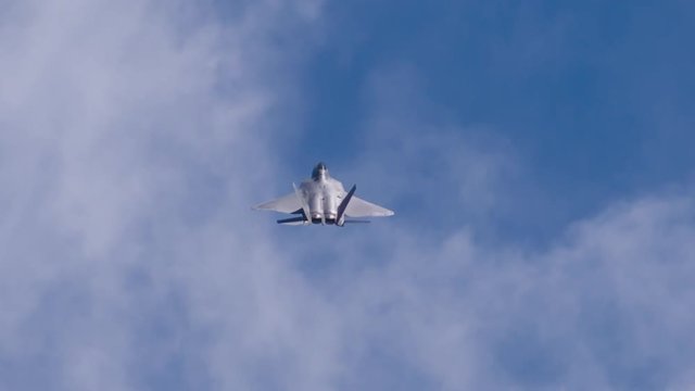 Tracking shot of F22 fighter jet flying in sky