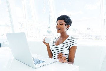 Smiling african american young businesswoman sitting at workplace