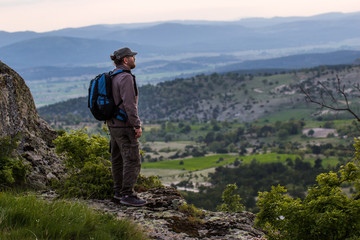 Naklejka na ściany i meble Man tourist hiker or trail runner looking in high mountains.