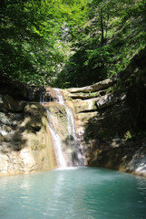 Gelendzhik district, Russia: Tourist route along Kuago river - one of cascading waterfalls. Noon, dazzling sunlight, drop lights and shadows