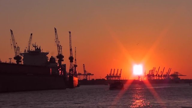 Trockendocks und Hafenkräne im Hamburger Hafen bei Sonnenuntergang