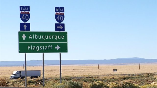 Interstate 40 signage, Albuquerque and Flagstaff, highway traffic in background.