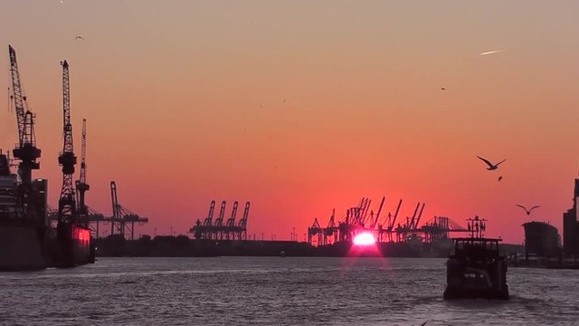 Trockendocks und Hafenkr&auml;ne im Hamburger Hafen bei Sonnenuntergang