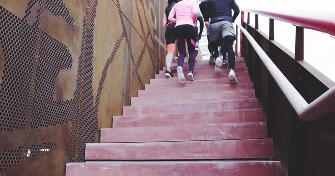 Group of people exercising together running up stairs