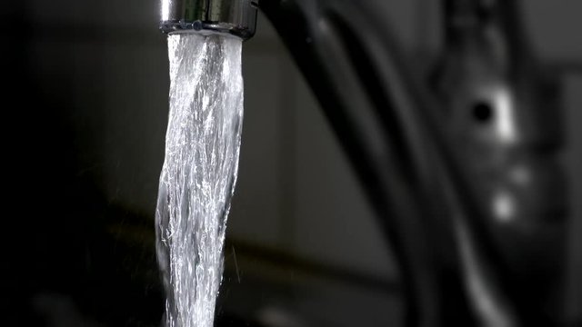 Close up shot of water flowing from the tap
