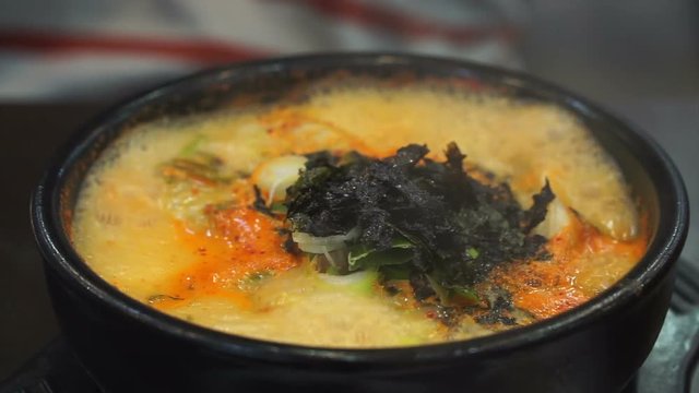 Korean style boiling spicy dumpling stew serve in hot pot